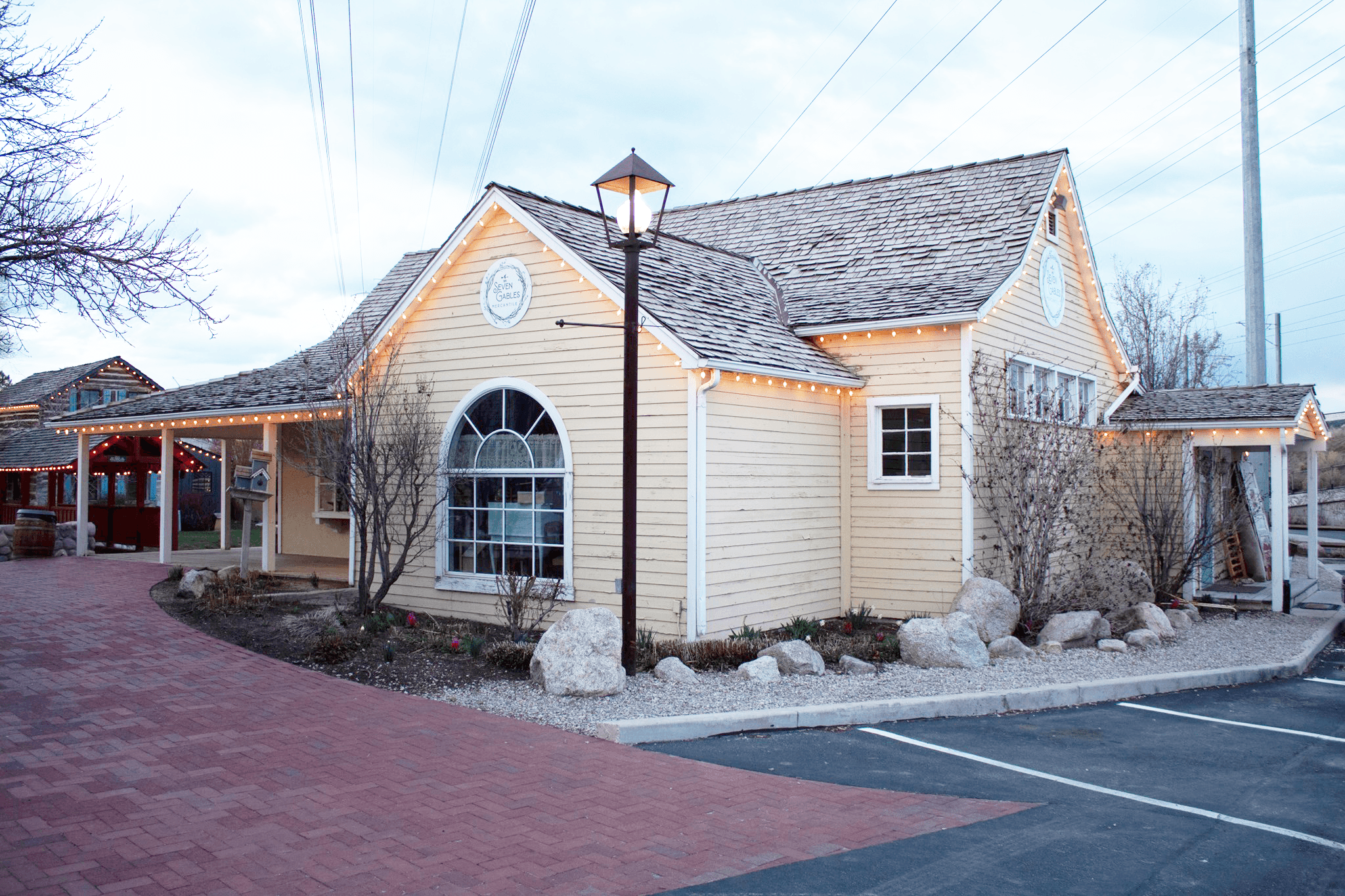 a yellow building with Seven Gables Mercantile logo and parking spaces