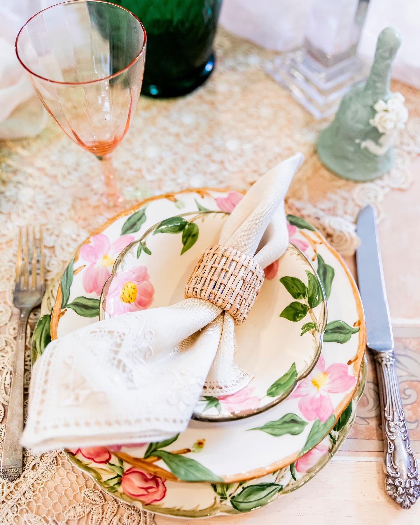 flowery china set with a napkin in a napkin ring set on a lace tablecloth