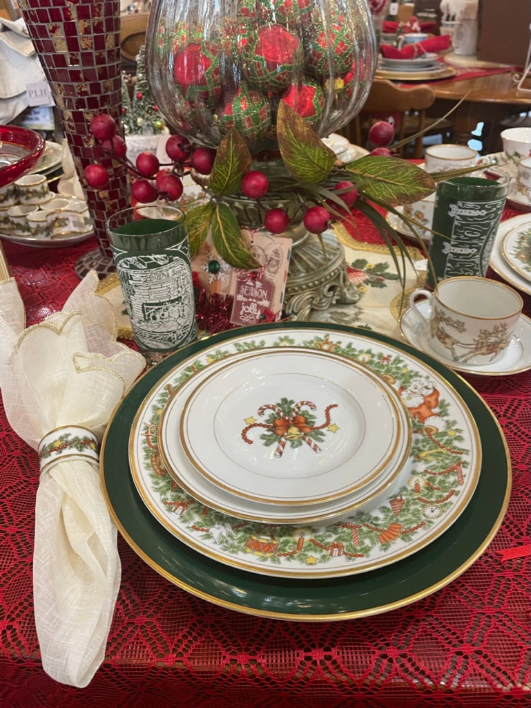 christmas china set on display with a red tablecloth
